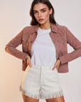 Western cowgirl woman wearing a blossom pink goat suede trucker jean jacket